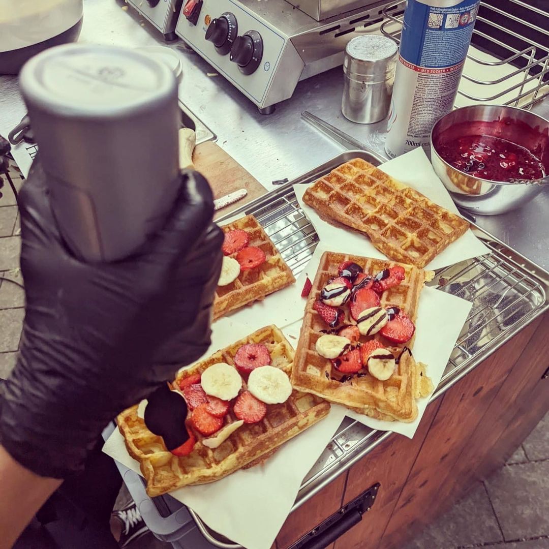 Puderzucker über einer Waffel mit frischen Früchten